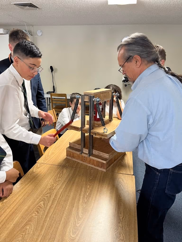 A Geneva Academy teacher guiding students through an engineering demonstration in Roseburg, Oregon