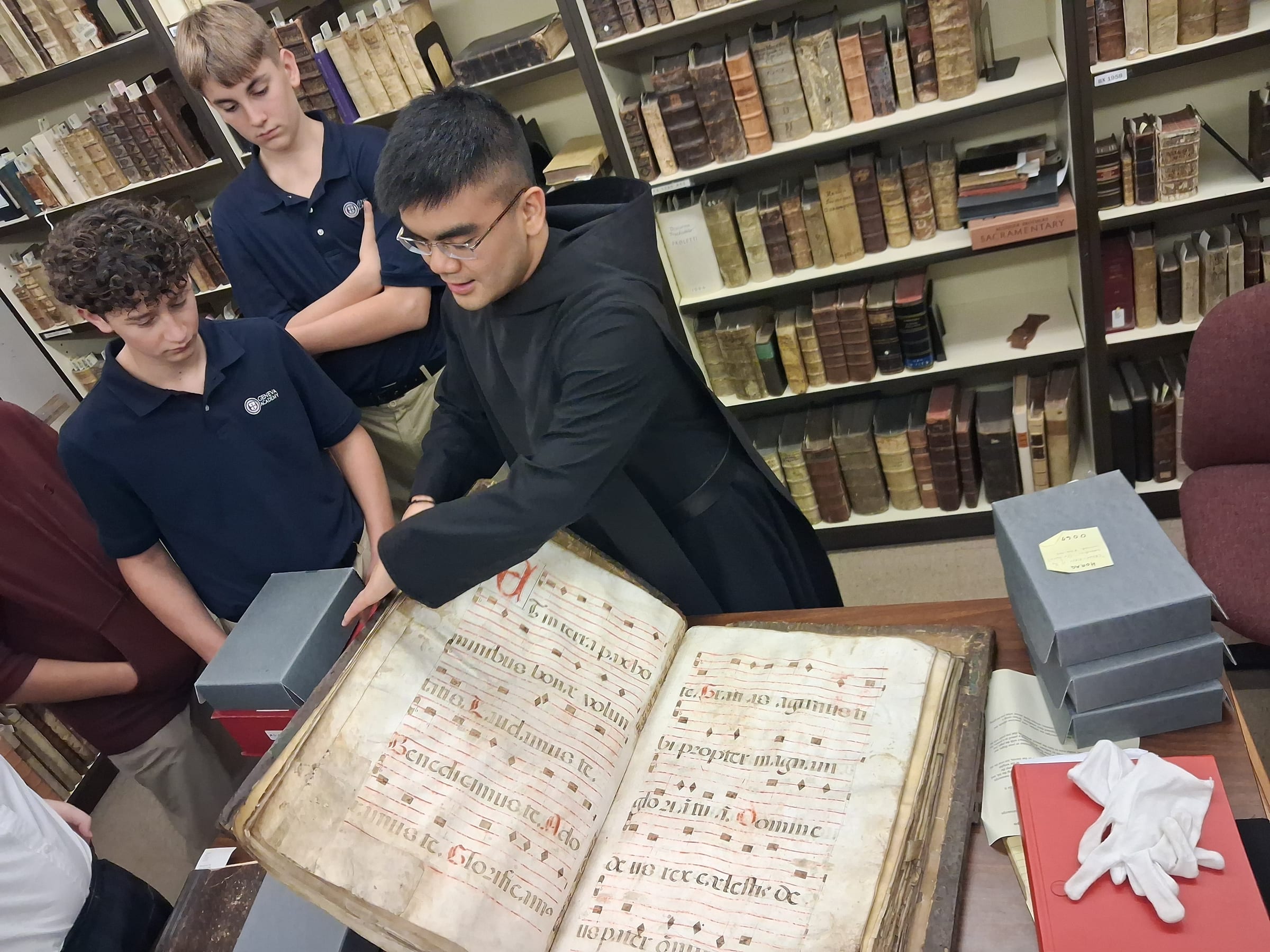 Geneva Academy students studying an illuminated medieval manuscript, Roseburg Oregon