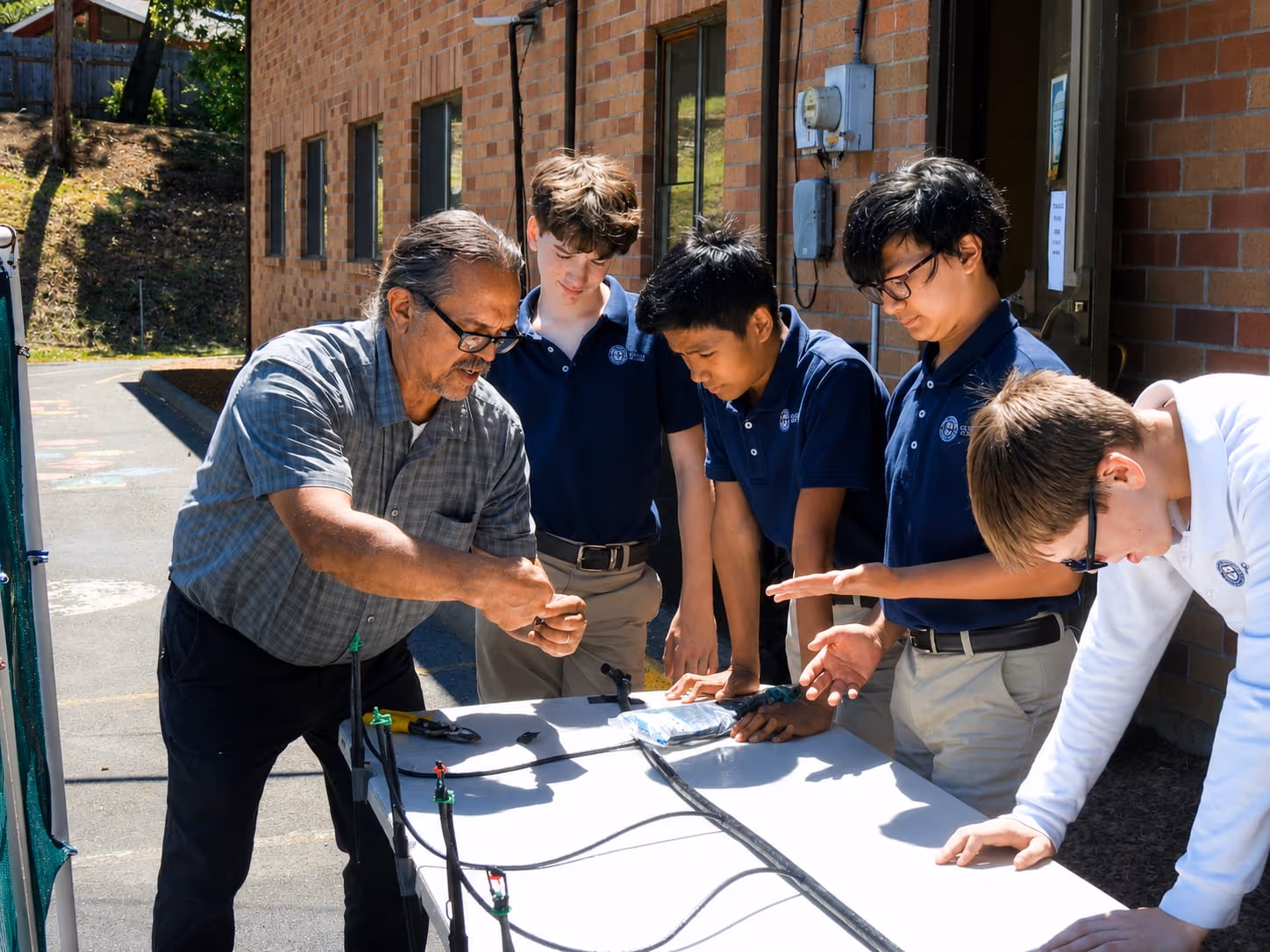 A Geneva Academy teacher leading a hands-on outdoor lesson at a classical Christian school in Roseburg, Oregon